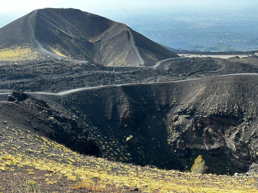 Catania: Etna Morning or Sunset Trek with Lava Tunnel & Gear - Entering a lava tunnel with helmet and flashlight